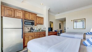 A hotel room with a kitchenette, two beds, and a bathroom visible through an open door. - Daytona Beach Resort 1404 (Daytona Beach)