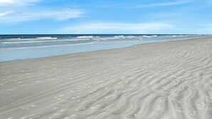 A sandy beach with gentle waves and a clear sky. - Point East 302 -just Beachy (New Smyrna Beach)