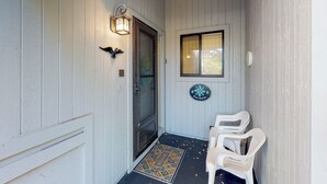 A porch with a door, a lantern, a window, and a welcome sign. - Sea Woods Villa 4412 - Villa at New Smyrna Beach (New Smyrna Beach)