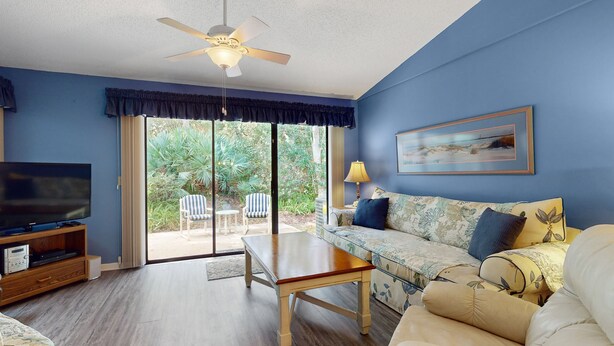 A living room with a TV, sofa, and table. - Sea Woods Villa 4412 - Villa at New Smyrna Beach (New Smyrna Beach)