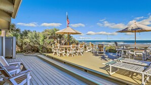 A deck with lounge chairs, a table, and umbrellas, overlooking the ocean. - Sea Dunes A1- Dream Catcher (New Smyrna Beach)
