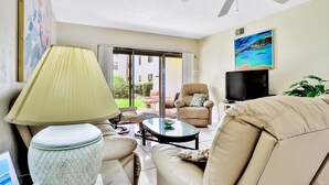 Una sala de estar con un sofá, un sillón y una mesa con una lámpara.