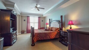 Une chambre à coucher avec un lit, une commode et un ventilateur de plafond.