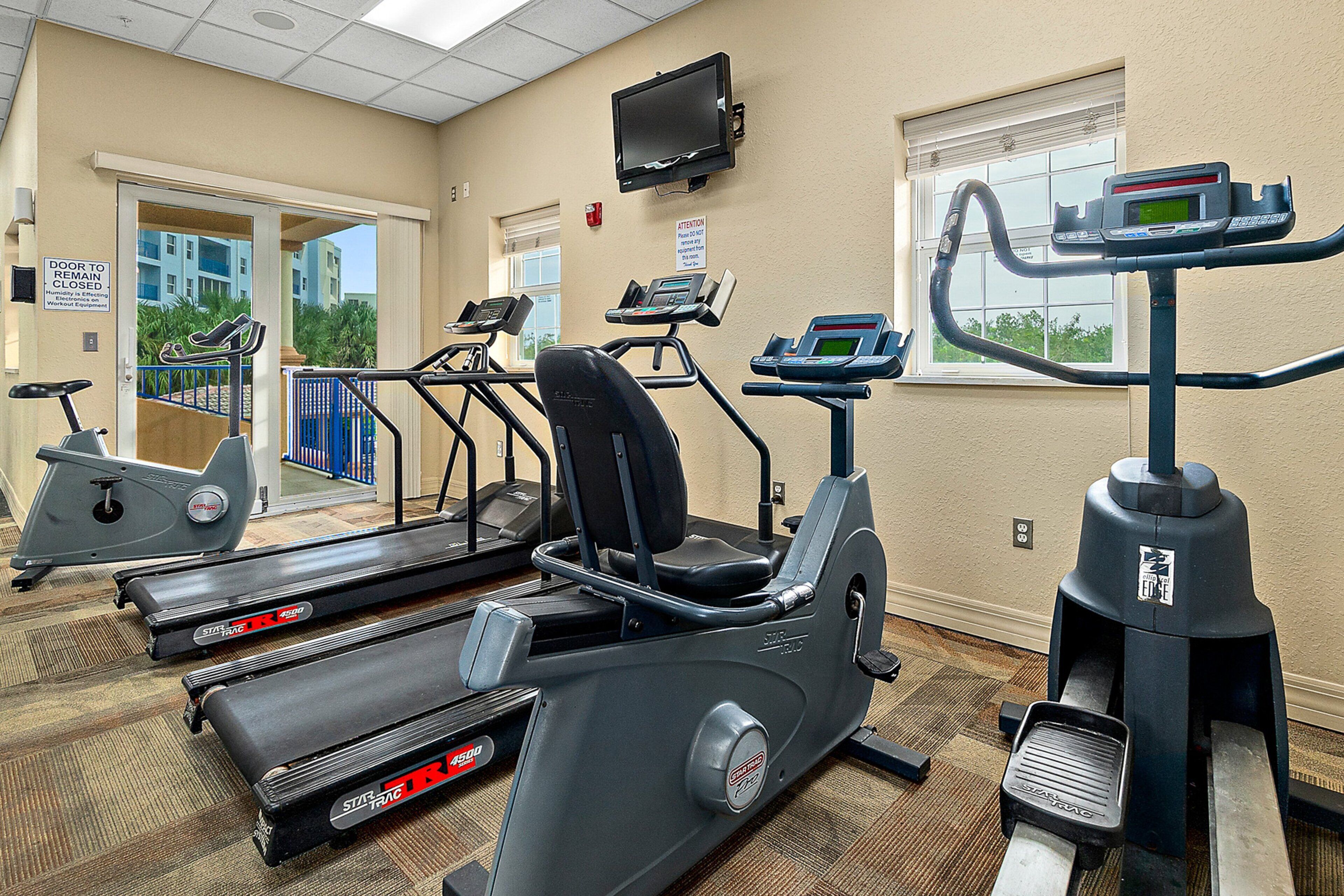 A fitness center with treadmills, elliptical machines, and a stationary bike.