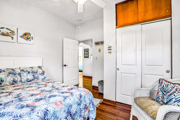 A bedroom with a bed, a chair, and a wardrobe. - River Cottage (Edgewater)
