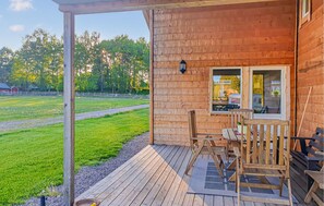 A wooden cabin with a porch, a table, and chairs. - 2 bedroom nice home in Sandhem (Sandhem)