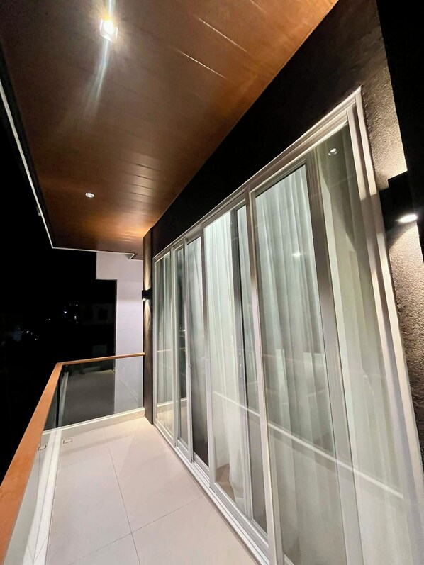 A modern balcony with glass doors and a wooden ceiling.