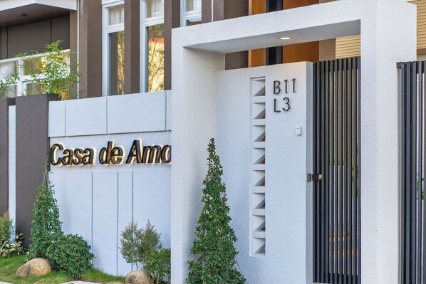 A modern building entrance with a sign reading 'Casa de Amo' and a gated entrance labeled 'B11 L3'.