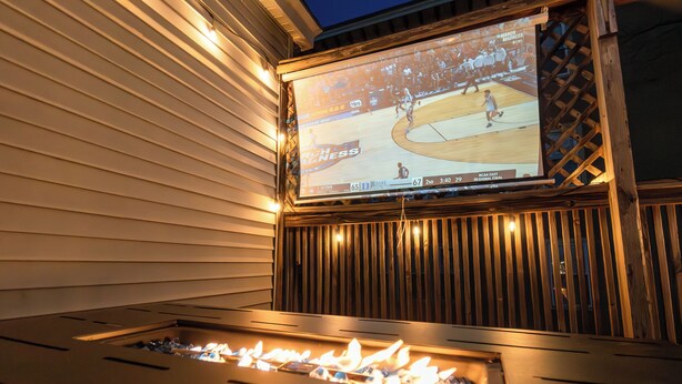 A fireplace with a screen displaying a basketball game. - Cozy 3Bed only 4min from tufts-10min from downtown Boston (Medford)