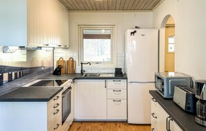 A compact kitchen with white cabinets, a built-in oven, a microwave, and a toaster. - Nice home in Långserud with WiFi (Långserud)