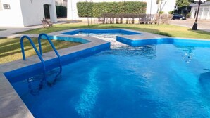 Una piscina con borde azul y una pequeña cascada.