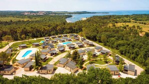 A residential area with multiple houses, a swimming pool, and a view of a body of water. - Holiday home with terrace (Tar/Poreč)