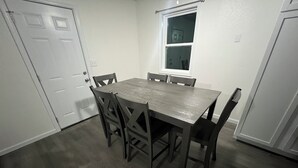 Una sala da pranzo con un tavolo rettangolare e sei sedie.
