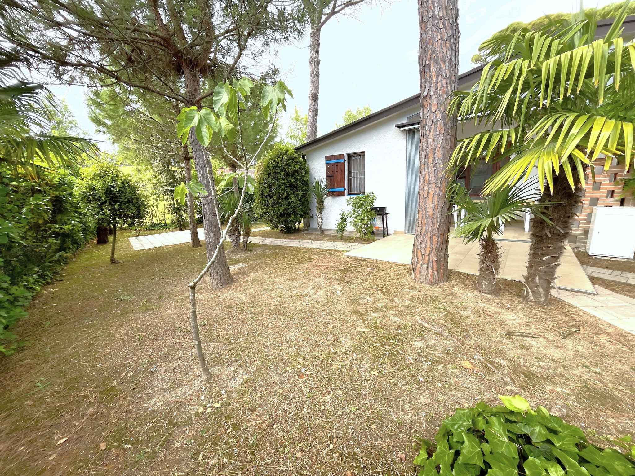 Una proprietà residenziale con un prato curato, diversi alberi e un edificio bianco con decorazioni blu.
