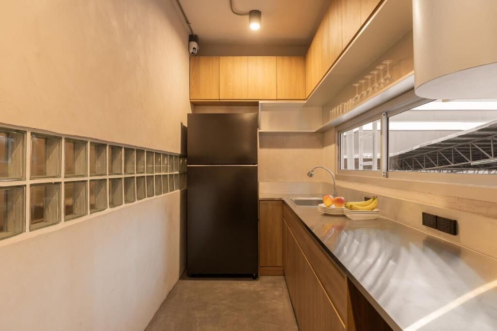 A compact kitchen with a refrigerator, a sink, and a window with a view of the outside.