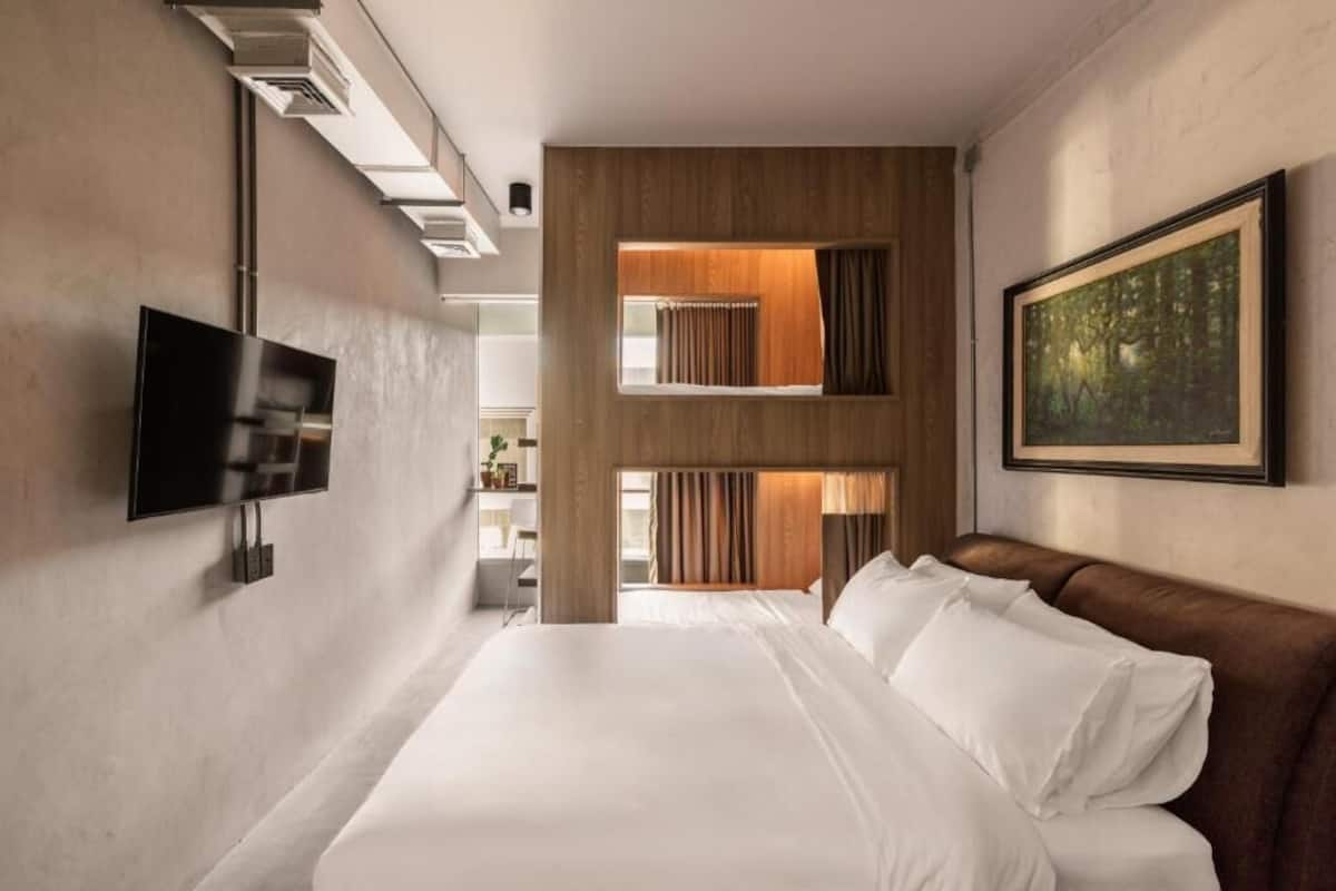 Een moderne hotelkamer met een groot bed, een flatscreen televisie, een schilderij en uitzicht op het landschap.