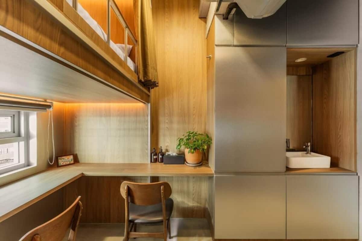 Een kleine keuken met een houten aanrecht, een spoelbak en een stoel.