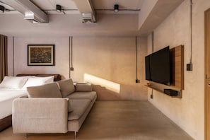 Une chambre à coucher moderne avec un lit, un canapé et un téléviseur.