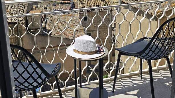 A balcony with two chairs and a small table, overlooking a mountainous landscape. - Modern Hillside Retreat with Panoramic Views & Private Balcony with AC (Mussomeli)