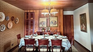 Une salle à manger avec un plafond en bois, des murs en briques et un lustre.