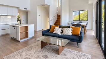 A modern living room with a sofa, coffee table, and a view of the outdoors.