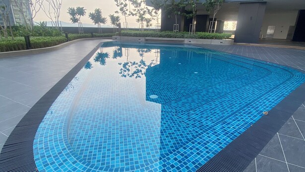 A swimming pool with a tiled edge and a surrounding tiled deck area. - becentral residence i-city (Shah Alam)