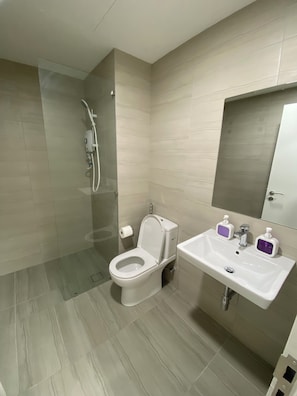 Ein modernes Badezimmer mit Toilette, Dusche und Waschbecken.