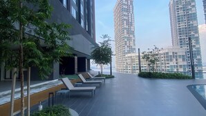 A modern urban plaza with high-rise buildings, outdoor seating, and greenery. - becentral residence i-city (Shah Alam)