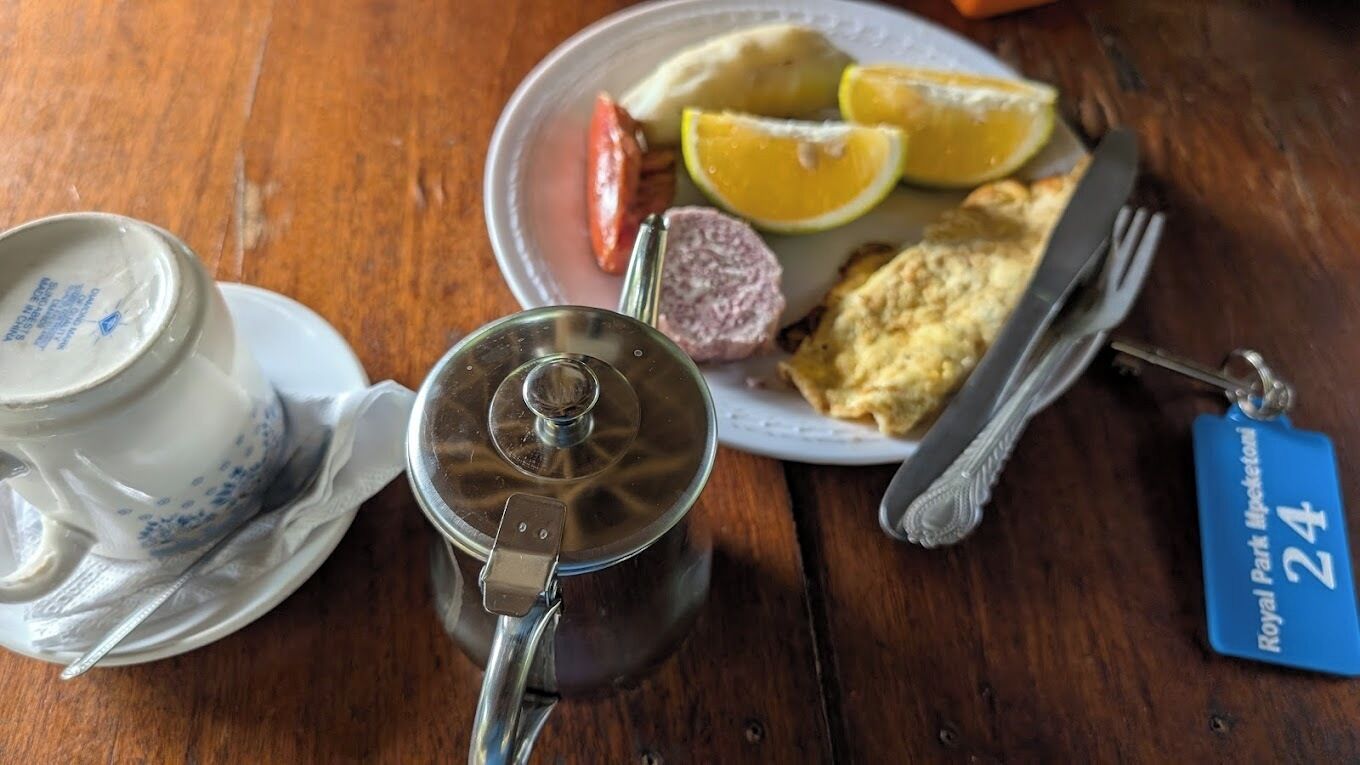 Une table avec une théière, une assiette de nourriture et un porte-clés.