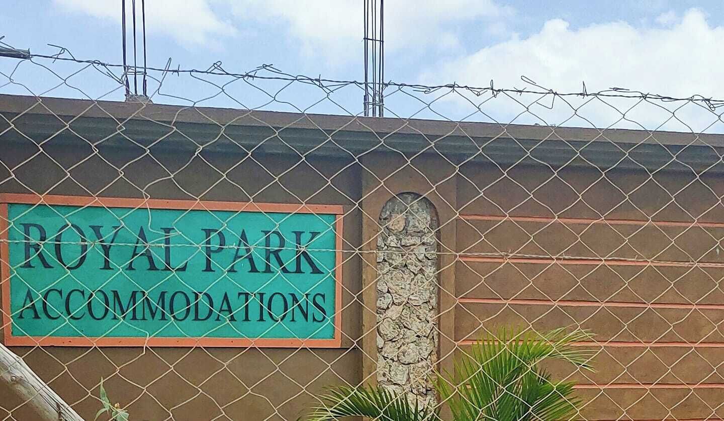 Un senyal per "ROYAL PARK ACCOMMODATIONS" darrere d'una tanca metàl·lica.