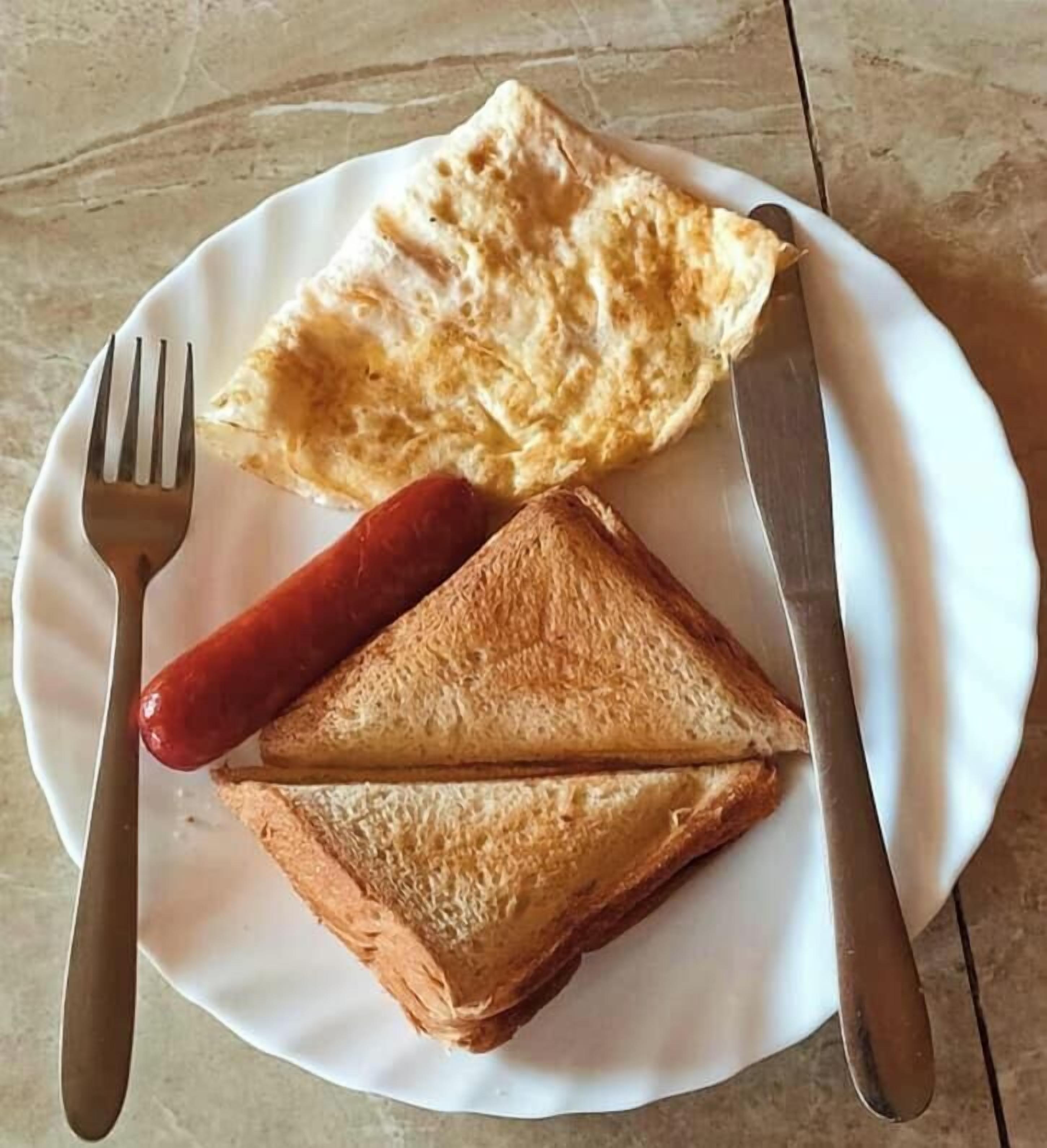 Un plat amb dues reeces de pa torrat i una salsitxa.