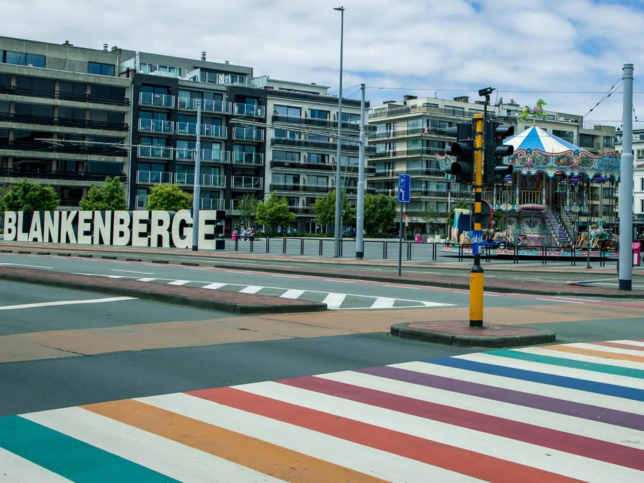 Une intersection avec un passage piéton et un carrousel en arrière-plan.