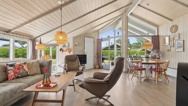 Un amplio espacio habitable con sofá, sillón, mesa de comedor y sillas.