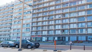 A multi-story building with a uniform facade, featuring balconies and large windows. - Studio on the 4th floor with sea view (Middelkerke)