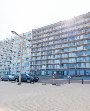 Ein mehrstöckiges Gebäude mit einheitlicher Fassade, das Balkone und große Fenster aufweist.