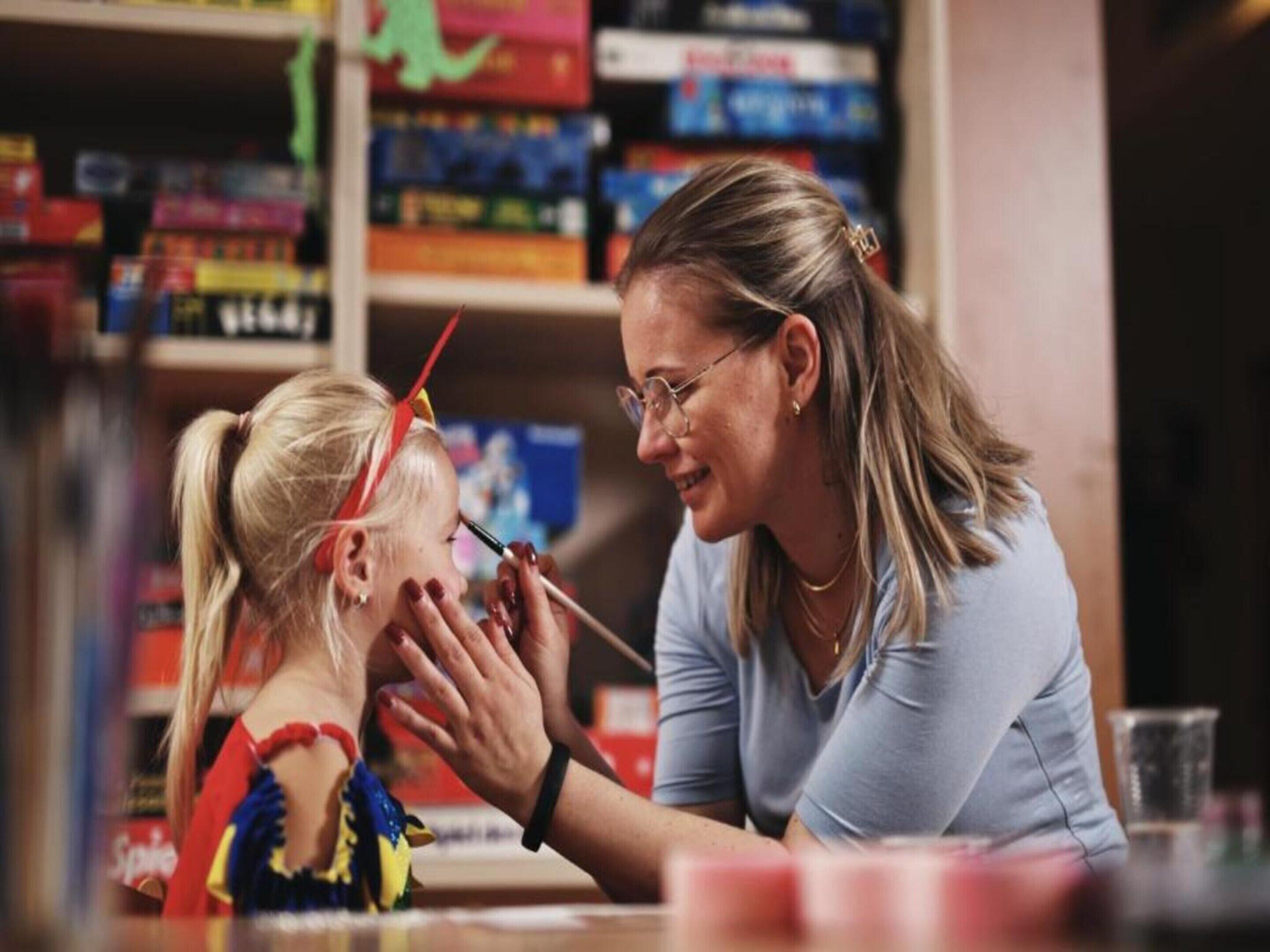 A woman and a child at a table with art supplies.