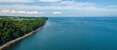 A coastal landscape with a clear view of the sea and a forested area.