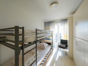 A bunk bed room with a desk and chair, a window with curtains, and a wardrobe. - Beautiful apartment on the 4th floor with garage (Middelkerke)