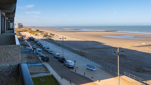 A coastal road with parked cars, a pedestrian walkway, and a beach in the background. - Beautiful apartment on the 4th floor with garage (Middelkerke)