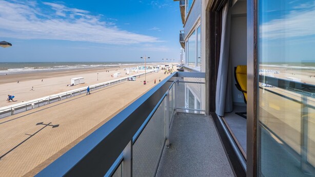 Ein Balkon mit Blick auf Strand und Meer.