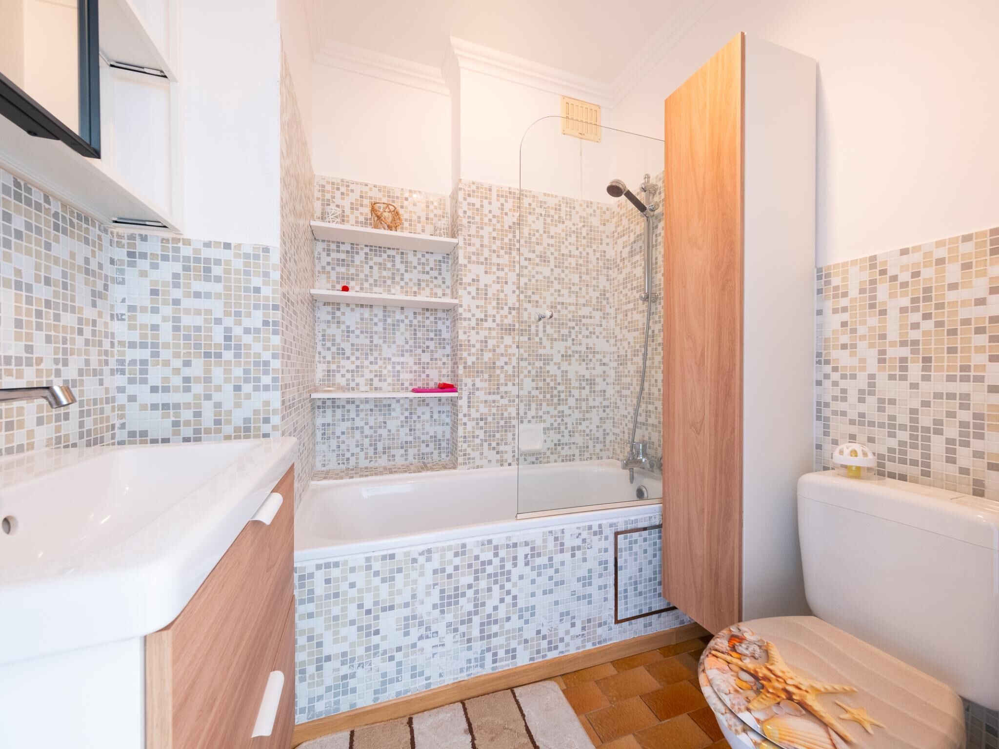 A bathroom with a bathtub, shower, and tiled walls.
