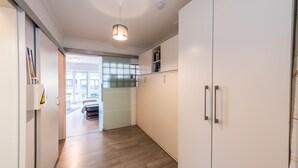 Een moderne keuken met witte kastjes, een houten vloer en een hanglamp.