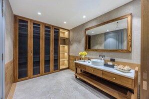 Ein modernes Badezimmer mit einem Holzbadezimmermöbel, einem großen Spiegel und einem Boden aus sechseckigen Fliesen.