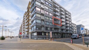 Un immeuble résidentiel à plusieurs étages, doté de balcons, d’un panneau indiquant un espace de stationnement et d’un panneau indiquant l’interdiction d’accès.
