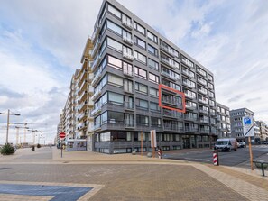 Ein mehrstöckiges Wohngebäude mit Balkonen, einem Parkschild und einem Verbotsschild.