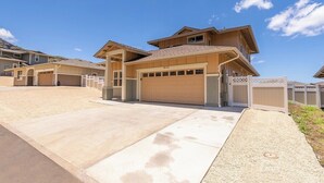 A modern two-story house with a garage, a driveway, and a gated entrance. - Marbella Lane - 7BR Home w Mountain Ocean Views (Waianae)