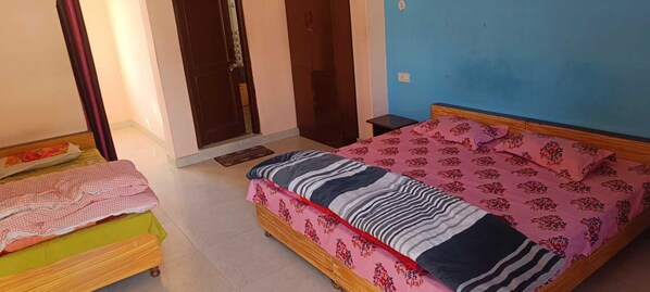 A bedroom with a bed, a bedside table, and a small table. - Bridge View Homestay (Manali)