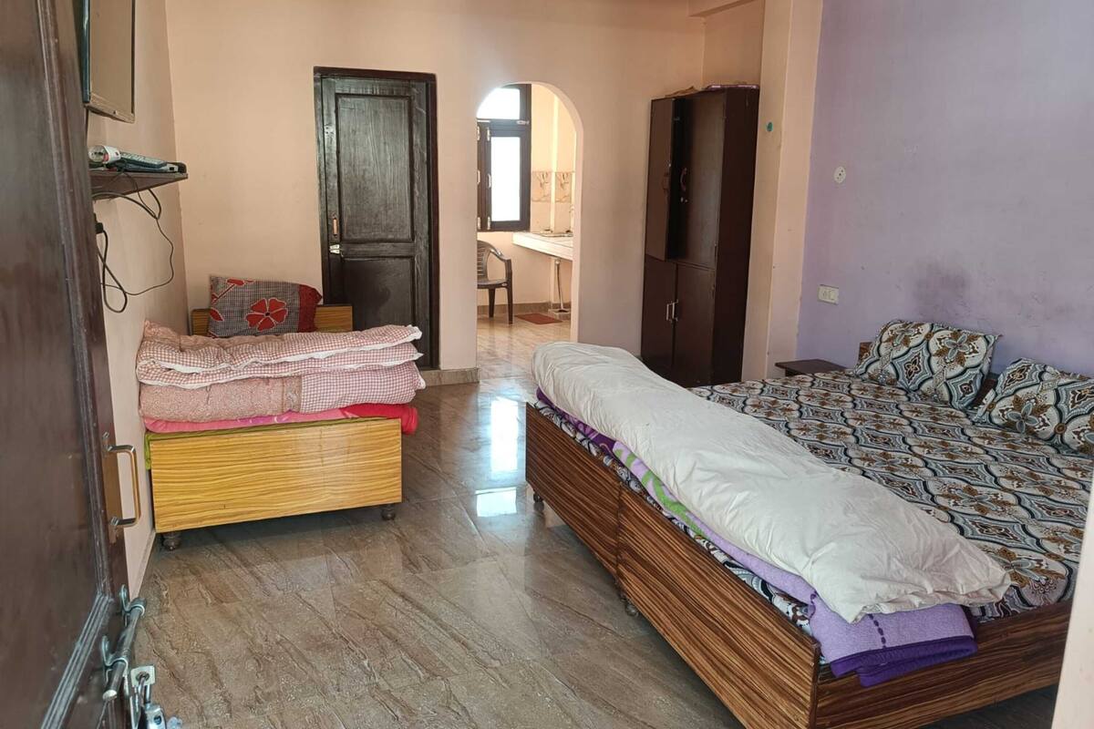 A bedroom with a bed, a wardrobe, a desk, and a chair.