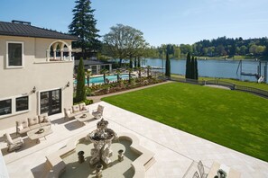 A house with a swimming pool, outdoor furniture, and a well-maintained lawn.
