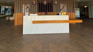 Un área de recepción con un separador de madera, una barra de mármol e iluminación colgante.